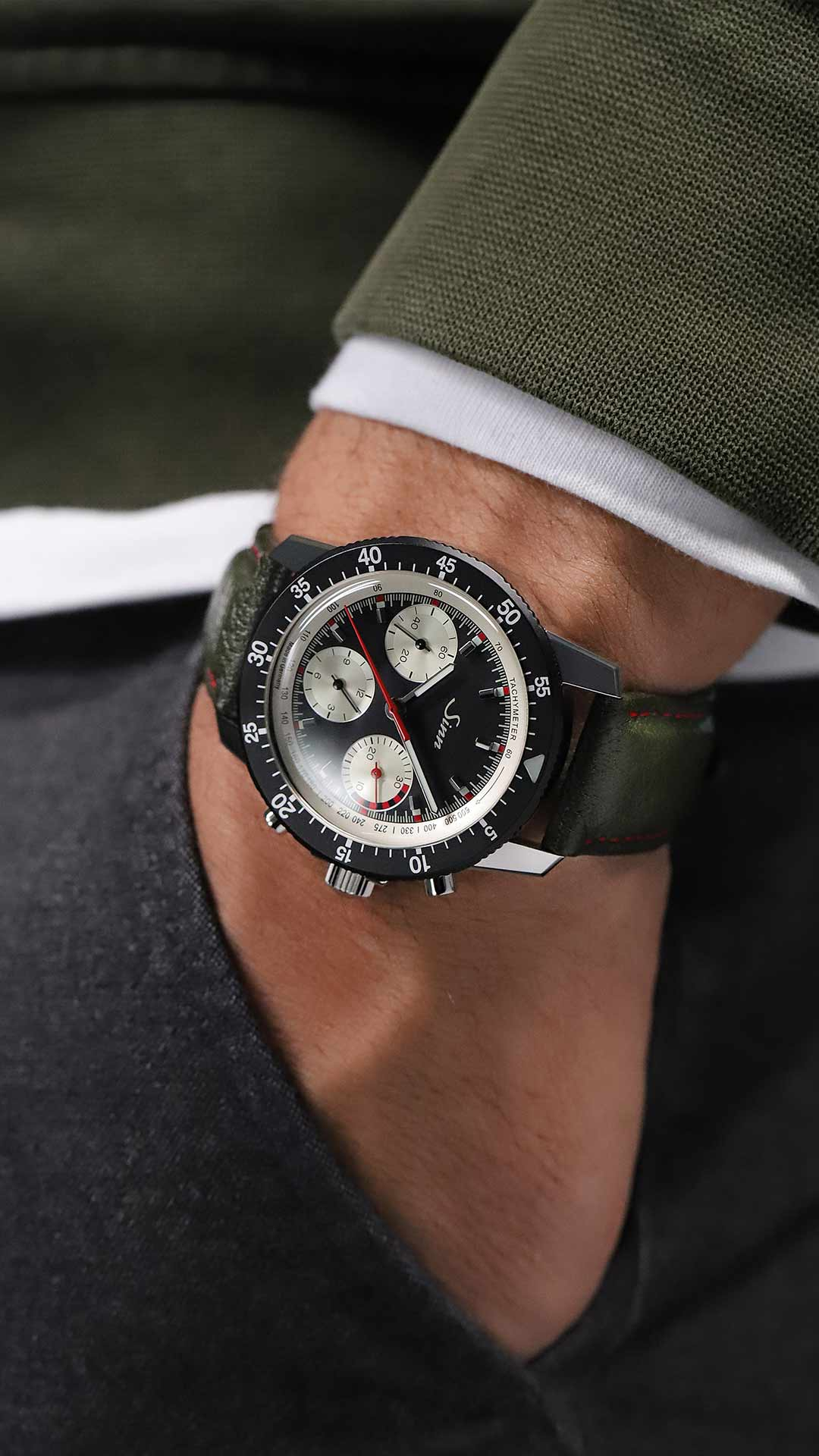 Sinn 103 St Ty Hd Chronograph mit schwarzem Zifferblatt, silbernen Totalisatoren und Lederarmband am Handgelenk.w