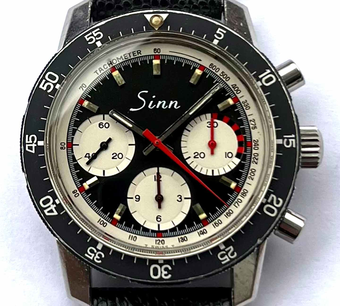 Sinn Uhr, schwarze Lünette, schwarzes Zifferblatt mit drei weißen Totalisatoren.