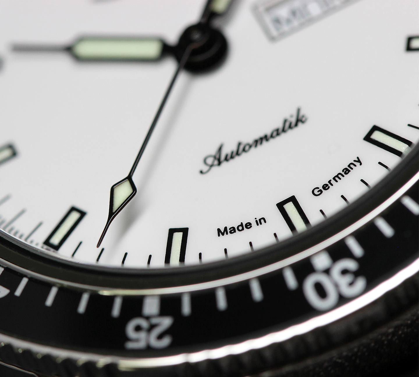Gros plan sur le cadran blanc de la Sinn 104 St Sa I W avec minuterie noire et aiguilles luminescentes.