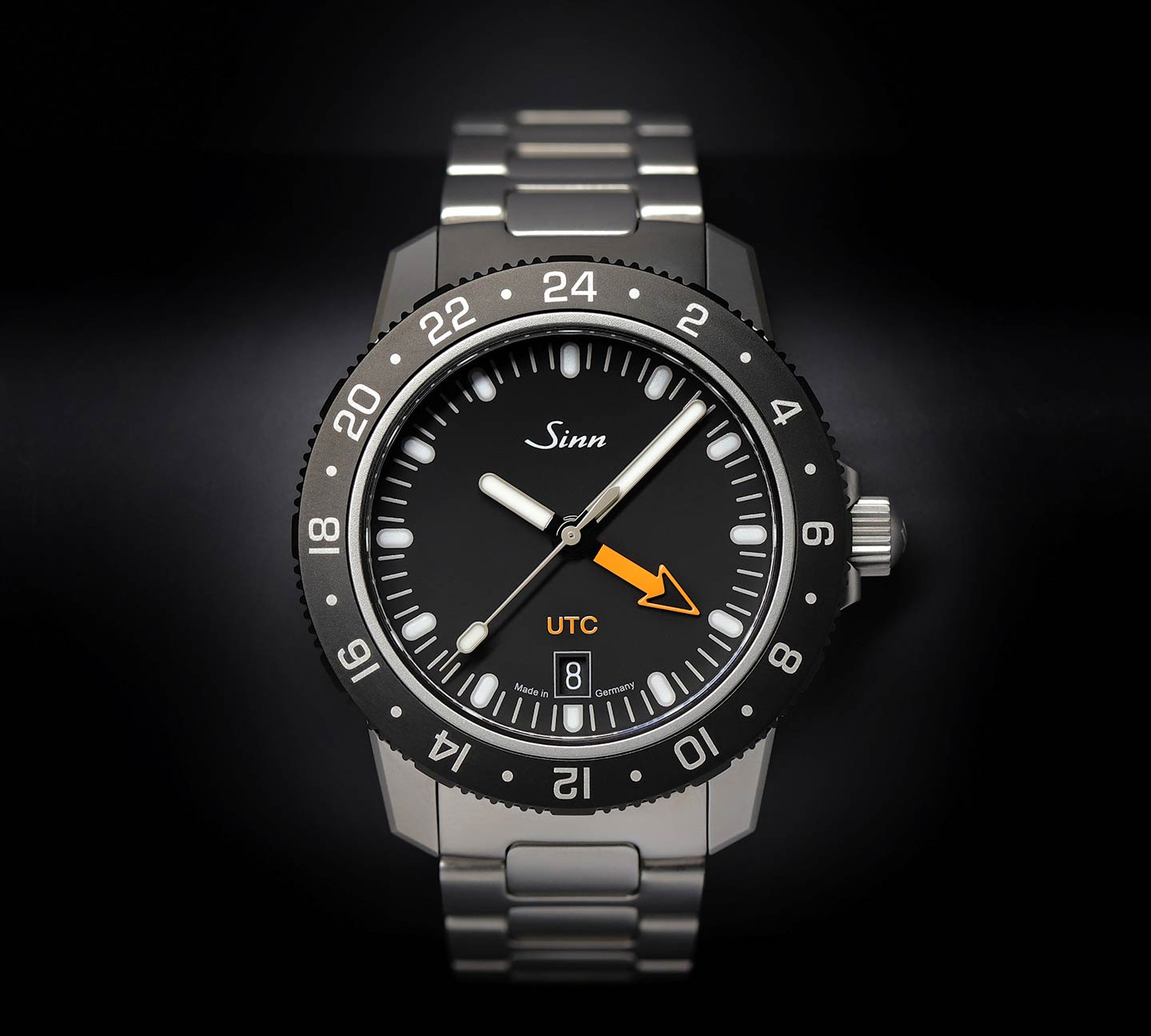 Sinn 105 St Sa UTC mit schwarzem Zifferblatt, orangefarbenem UTC-Pfeilzeiger und Edelstahlarmband.