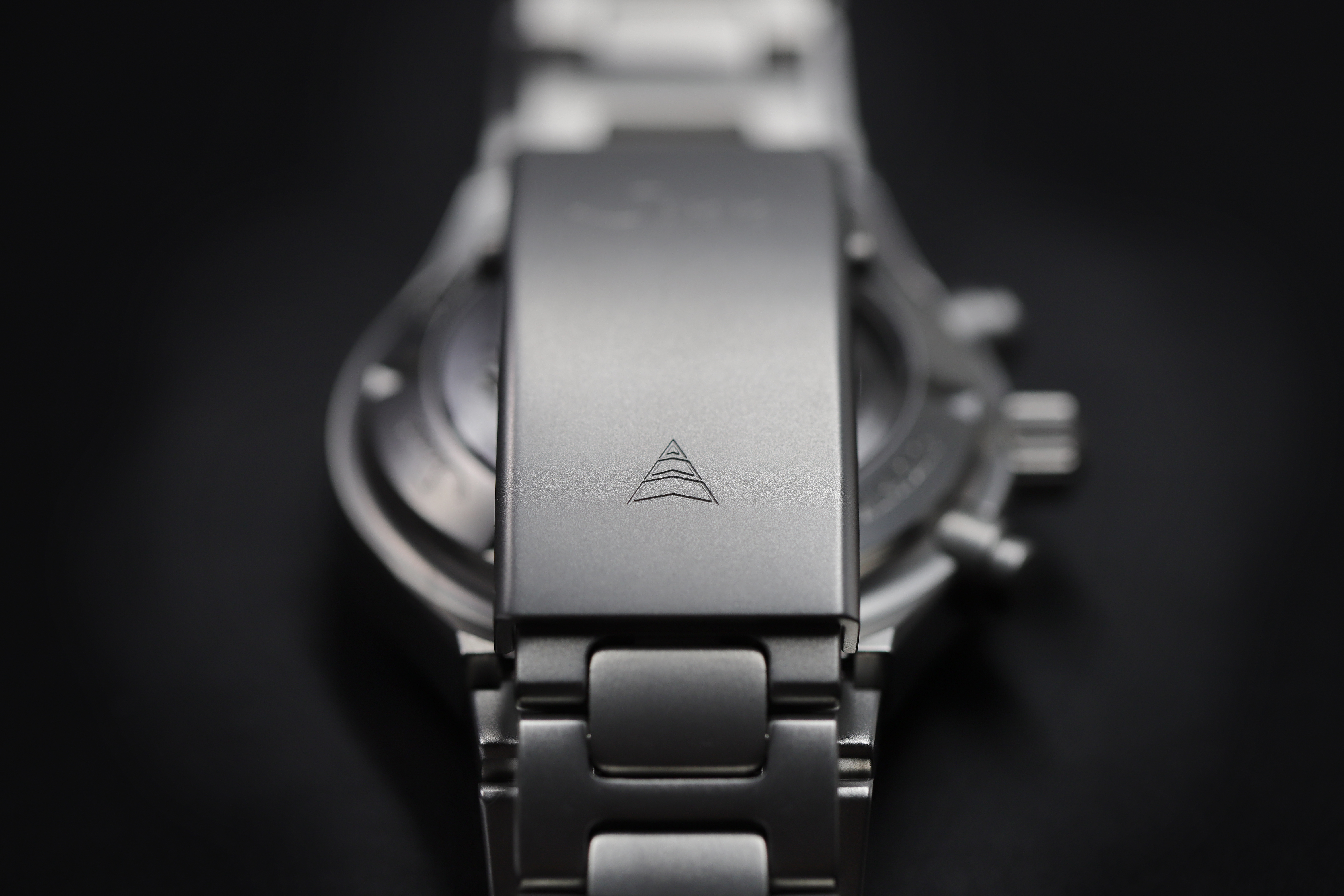 Close-up of the folding clasp of a solid stainless steel bracelet with engraved Sporthilfe logo.