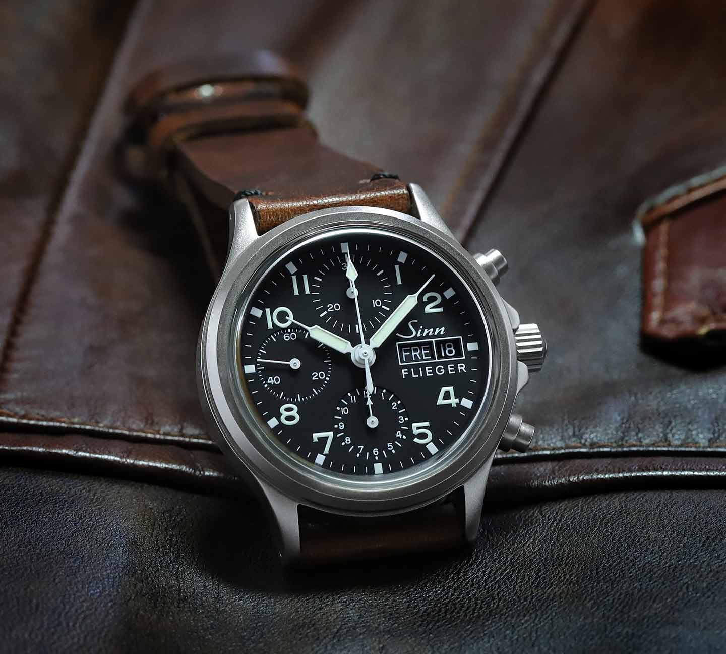Sinn 356 Flieger avec bracelet en cuir brun sur une veste en cuir brun.