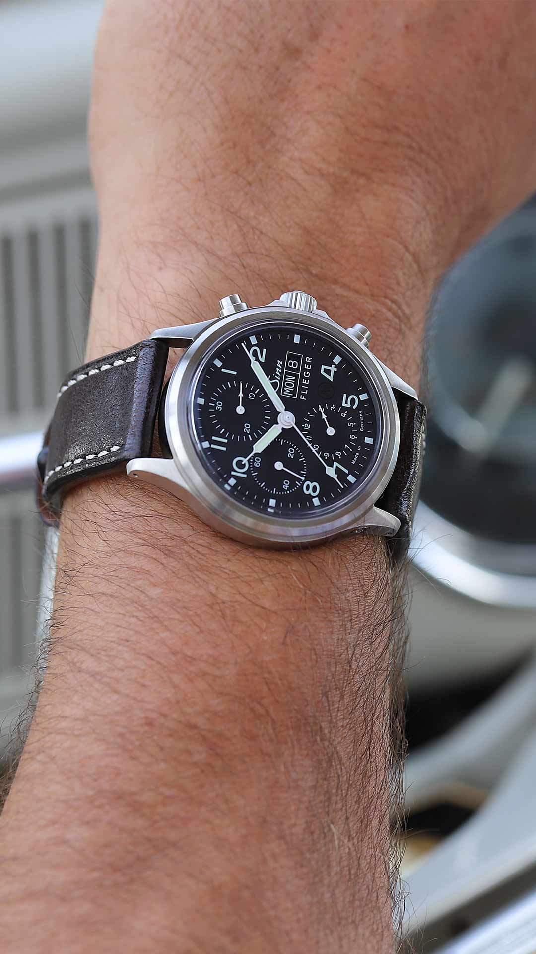 Sinn 358 Sa Flieger au poignet avec cadran noir et bracelet en cuir.