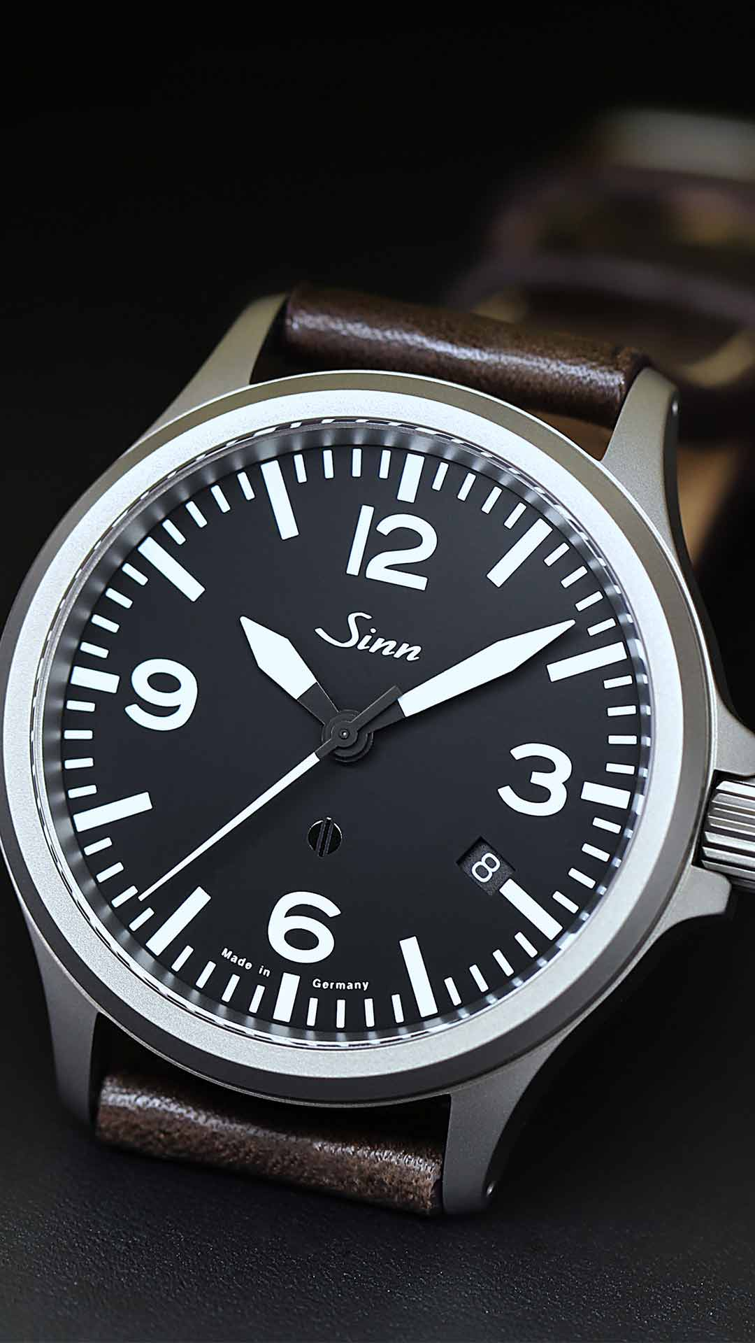Sinn 856 mit schwarzem Zifferblatt am Lederband.
