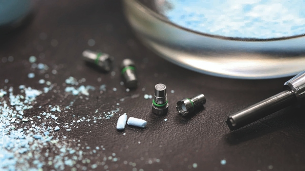 Four Ar capsules, next to them the white-bluish copper sulphate.