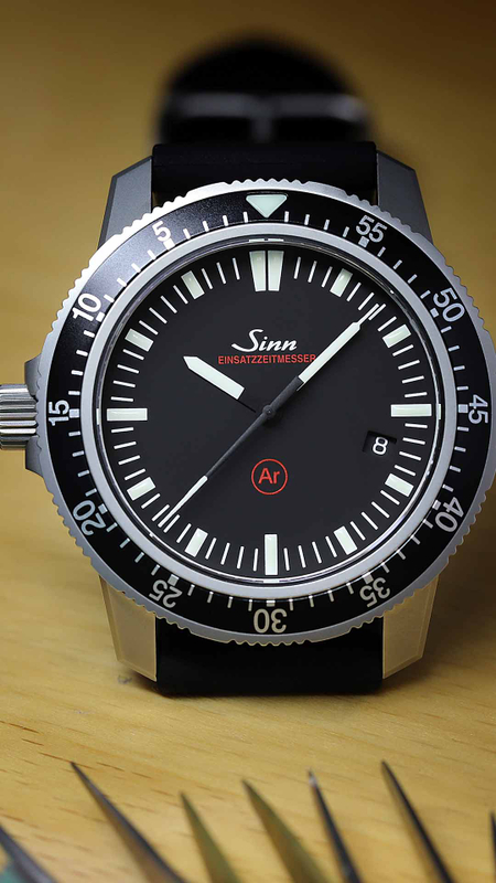 Sinn EZM 3 F with black dial and diver bezel on light background.
