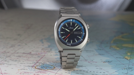 Sinn 240 St GZ mit blauem Zifferblatt, innenliegender Gezeitenlünette und Edelstahlband, stehend auf einer Seekarte fotografiert.
