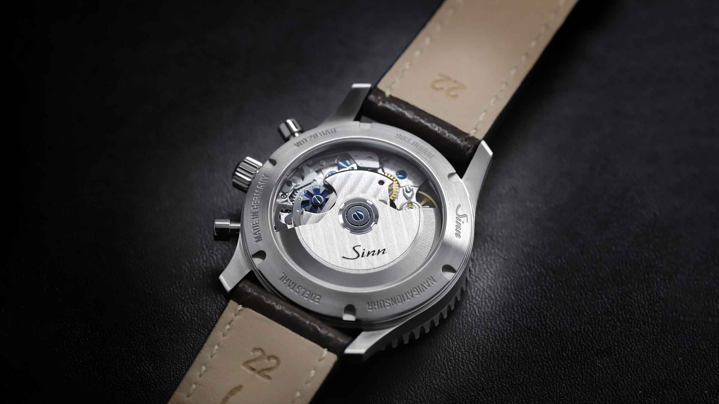 Montre Sinn avec fond transparent et boîtier en acier inox sur fond sombre.