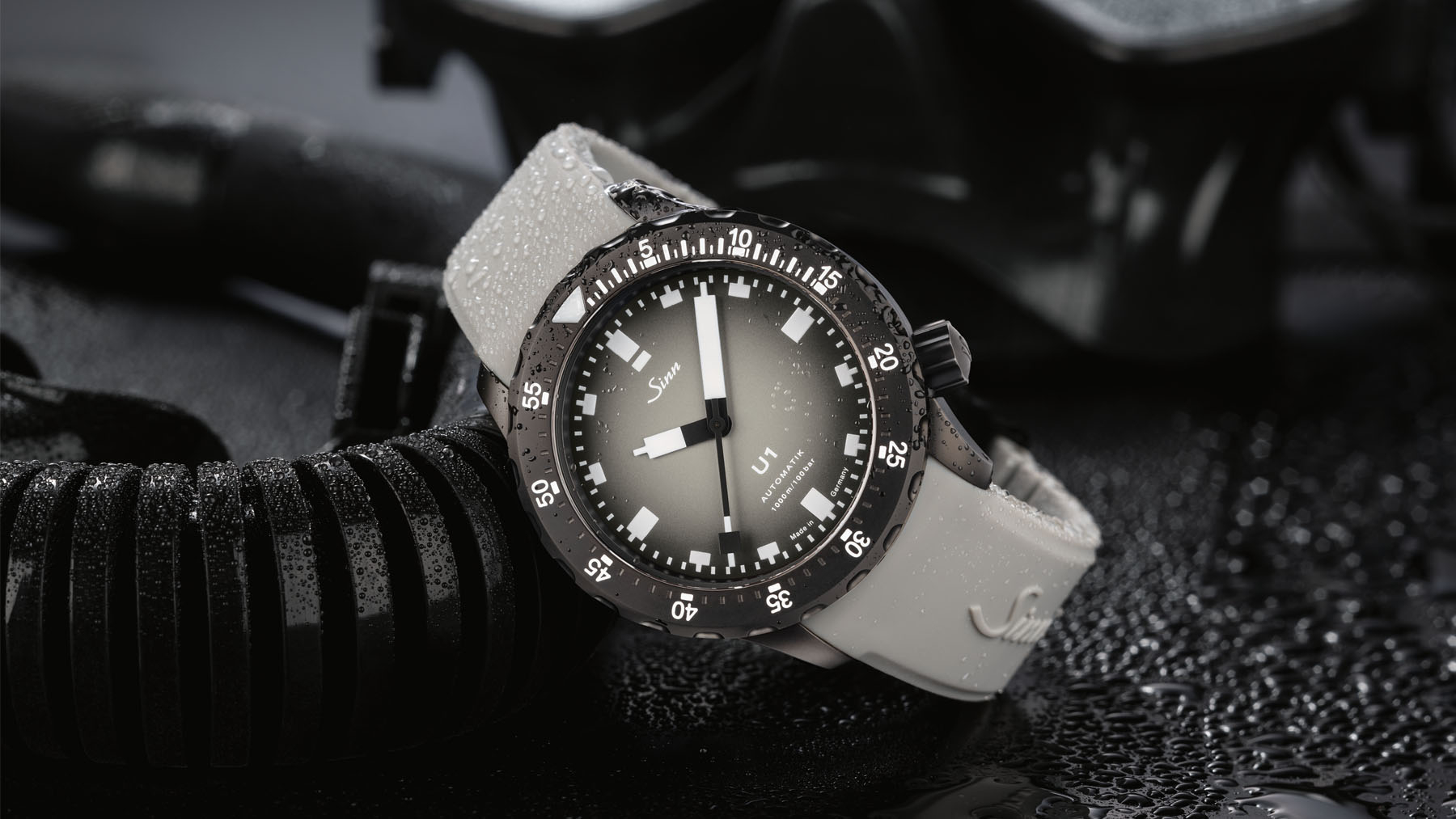Limited-edition Sinn U1 C HAI diver’s watch with light silicone strap and matte black bezel, presented with diving equipment and water droplets.