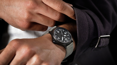                       Sinn 856 S avec boîtier noir, cadran noir et grands chiffres blancs, portée avec bracelet textile gris.
                  