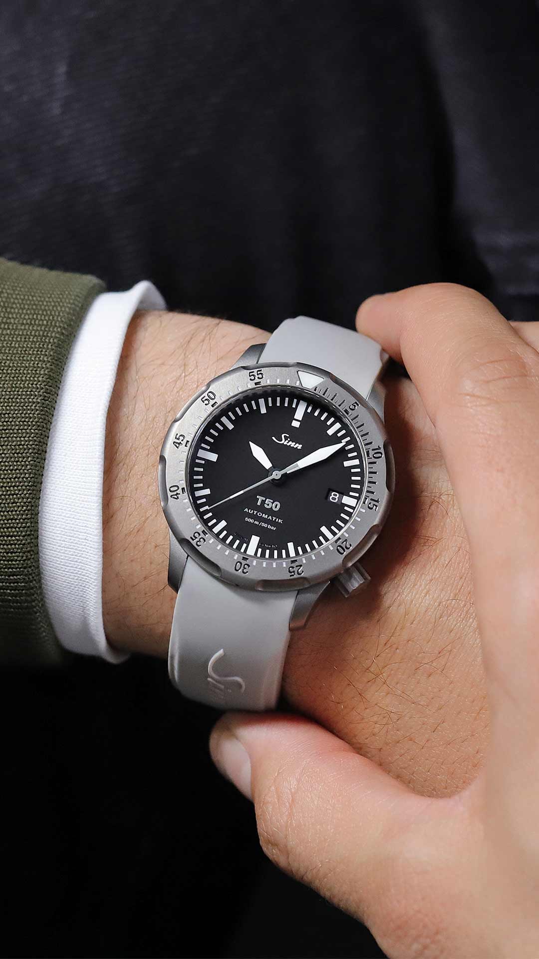 Robust und funktional: die T50 mit grauem Silikonarmband am Handgelenk.