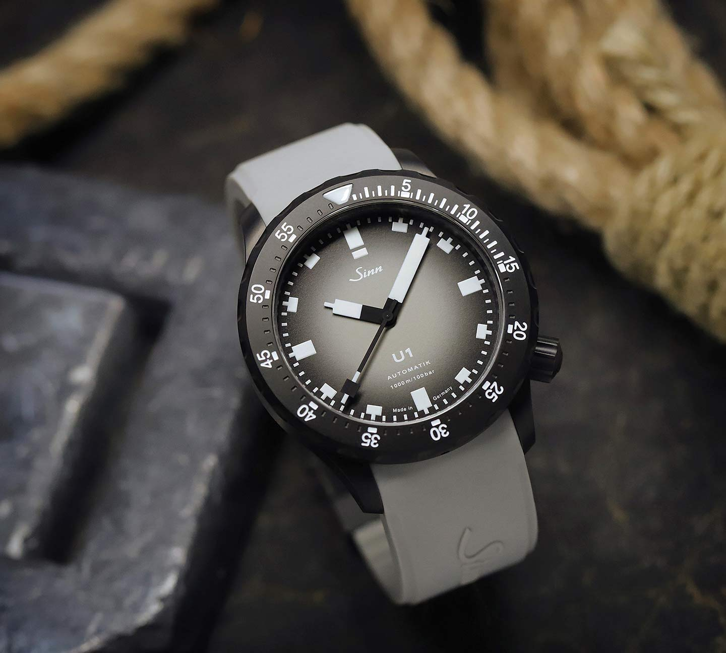 Sinn U1 Chai mit grauem Farbverlauf-Zifferblatt und grauem Silikonarmband, neben einem Seil platziert.