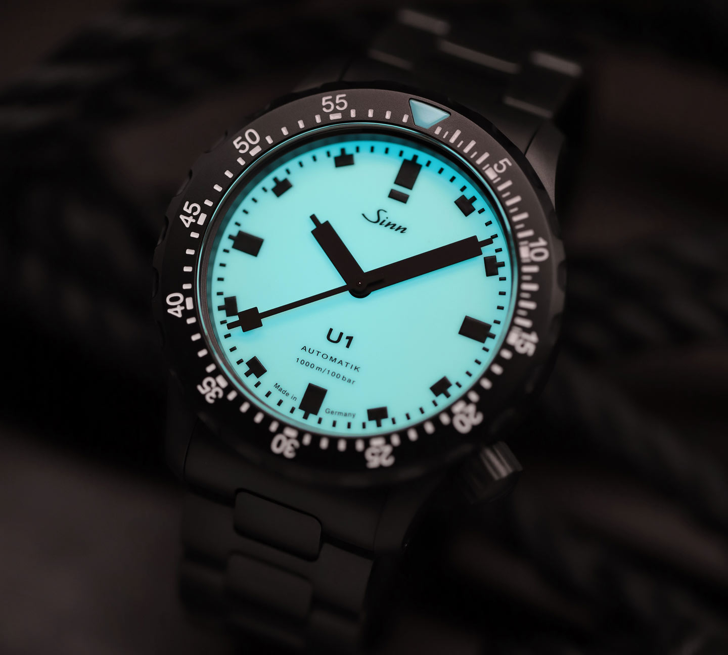 U1 S L with black case and luminescent dial, set against a dark background.