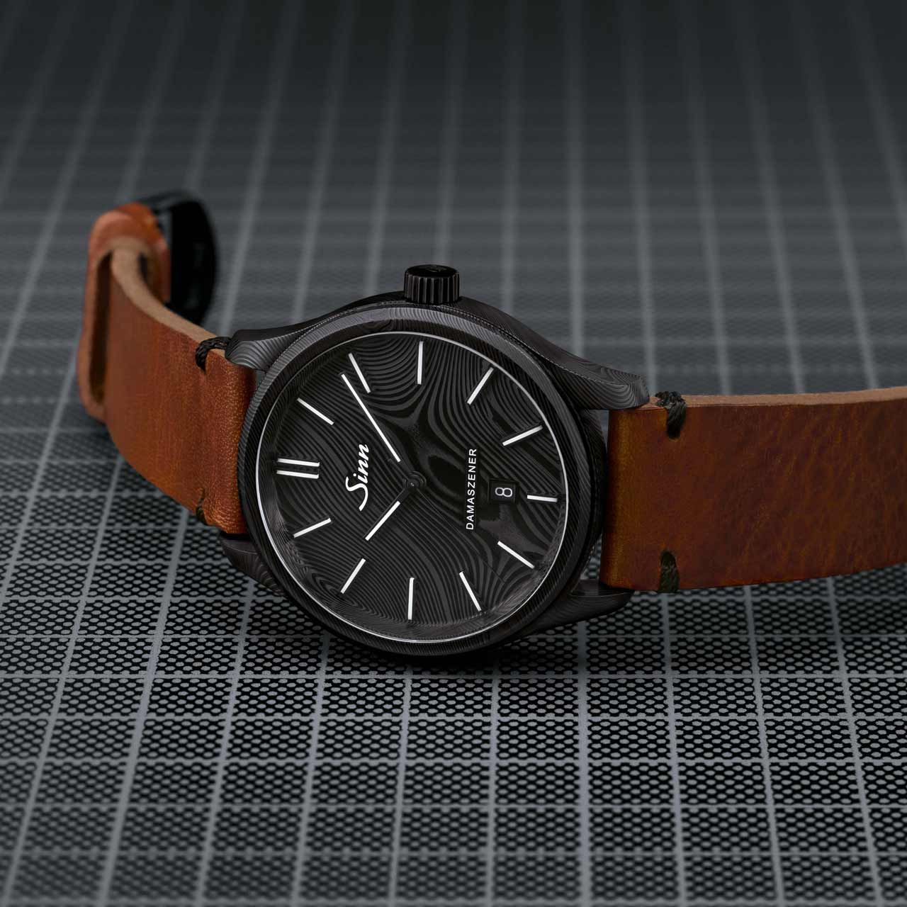 Model 1800 S DAMASZENER with wave-pattern dial and black Damascus steel case, placed on dark grid background with brown leather strap