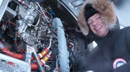Technicien inspectant le moteur ouvert d’un EC 145 T2 au sol dans des conditions hivernales.